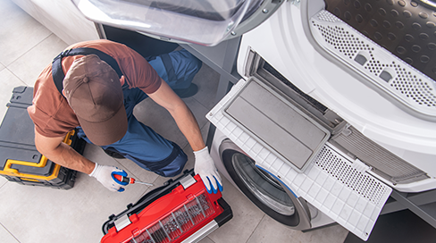 Specialized gas-fitter technician diagnosing a gas dryer igniter and flame sensor during a repair service in Stittsville, Ottawa