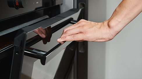 Techman technician inspecting oven door hinges and seals during a same-day stove and oven repair in Ottawa, Kanata, and Orléans.