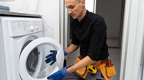 Professional technician replacing a failed drain pump during a washing machine repair service in Nepean, Ottawa